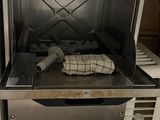 un four ouvert avec une bouteille d'eau posée sur le plan de travail