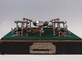 une maquette en métal d'une machine à vapeur posée sur une table verte