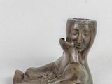 a small statue of a woman holding a cup