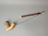 une pipe et un bâton en bois posés sur une table