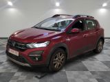 la voiture rouge est garée sur le sol en damier d'un garage