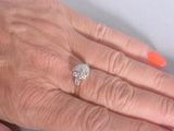 a woman ' s hand with a diamond ring on it