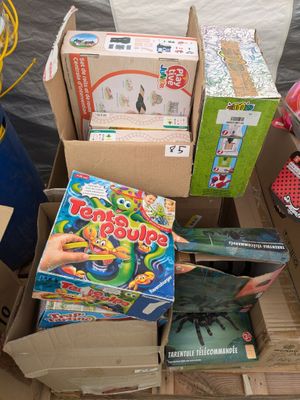 une boîte remplie de jouets et de livres posée par terre