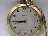 a gold pocket watch with a chain hanging from it