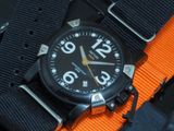 a close up of a watch on a black and orange strap