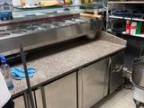un homme debout devant un plan de travail dans une cuisine