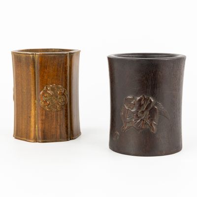 paire de vases en bois ornés de motifs sculptés sur un fond blanc