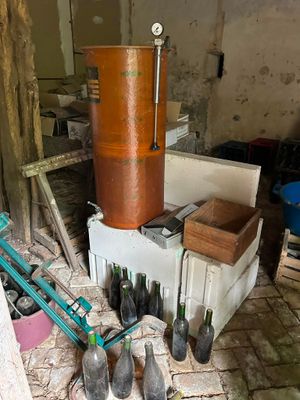 a large copper pot sitting on top of a table next to bottles