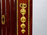a small wooden cabinet with gold decorations on it