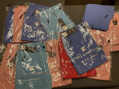 de nombreuses chemises emballées dans du plastique, posées sur une table