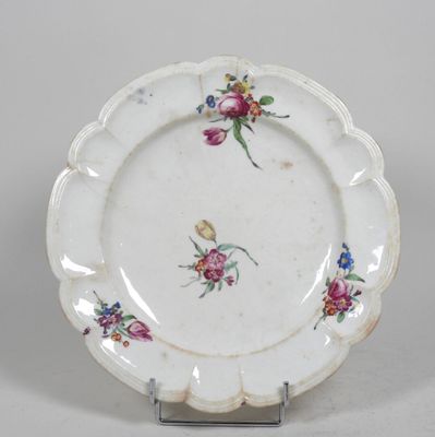une assiette blanche décorée de fleurs, posée sur un socle