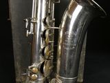 a silver saxophone that is sitting on a black surface