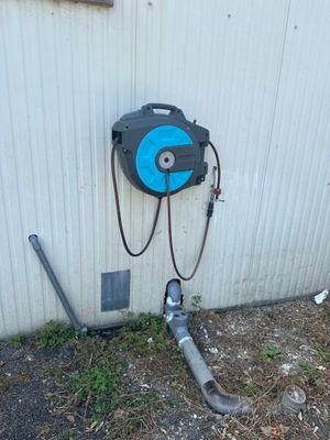 un tuyau raccordé au mur d'un immeuble, à côté d'une canalisation