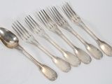 six forks and a spoon on a white table