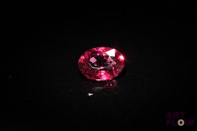 a close up of a pink diamond on a black surface