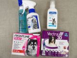 a dog sitting next to a bottle of spray and a package of toothpaste