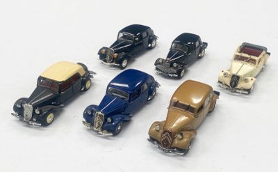 plusieurs petites voitures sont alignées sur une surface blanche