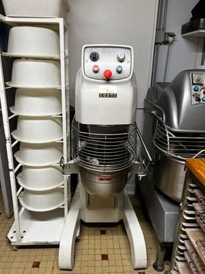 une photo d'une cuisine avec un mixeur et une pile d'assiettes