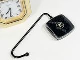 a small clock and a hook on a white table
