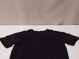 a black t shirt sitting on top of a white surface