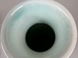a white vase with a black hole in it
