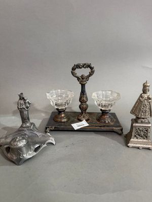 trois figurines en argent et un bougeoir en argent posés sur une table