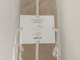 brown and white striped napkins wrapped in plastic on a white table