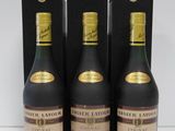 three bottles of liquor sitting on top of a table next to each other
