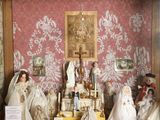 de nombreuses figurines dans une vitrine, avec un tableau accroché au mur