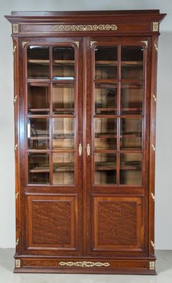 a large wooden bookcase with glass doors and gold trimmings