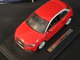 a red car that is on display on a black surface