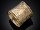a gold cuff bracelet with a design on it