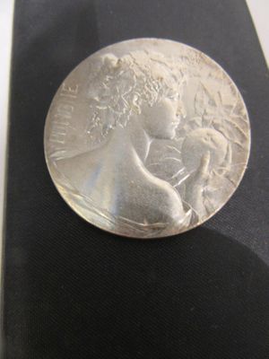 a silver coin sitting on top of a black case
