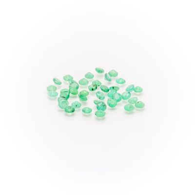 a pile of green emerald gems on a white background