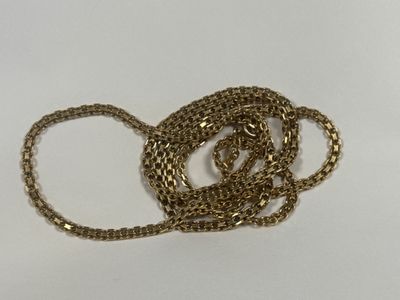 a close up of a gold chain necklace on a white surface