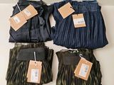 three pairs of pants with tags on them sitting on a table