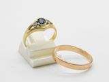 a close up of two gold rings on a white surface