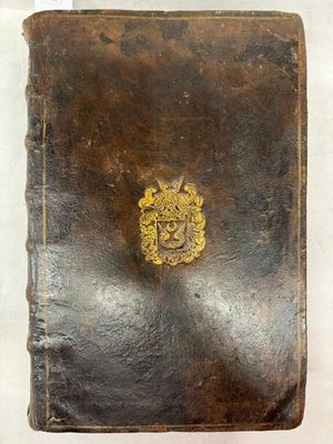 un vieux livre relié en cuir orné d'un emblème doré