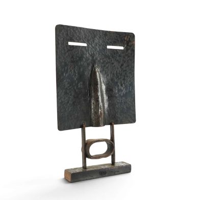 une photo d'une sculpture métallique représentant le visage d'un homme, posée sur un socle