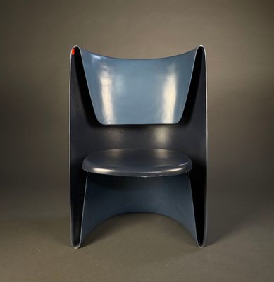 a black chair with a blue seat on a brown background