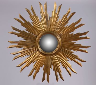 un miroir doré en forme d'étoile accroché au mur