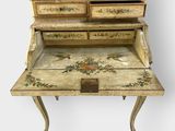 an old writing desk with a bird motif on the top of it