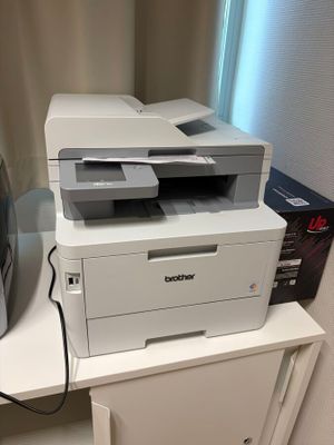 une imprimante blanche posée sur un meuble blanc