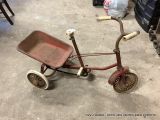 un tricycle rouge qui se trouve dans un garage