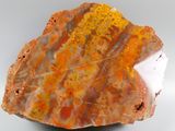 an orange and white rock with a leaf on top of it