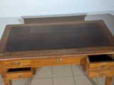 a wooden desk with a glass top and two drawers