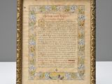 a framed picture of a poem in a gold frame on a white table