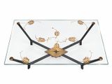 une photo d'une table basse en verre et en métal, sur laquelle sont posées des feuilles