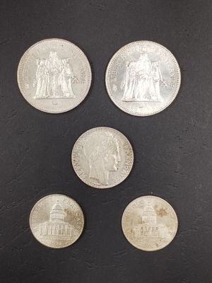 un groupe de cinq pièces d'argent posées sur une surface noire