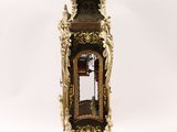a clock that is sitting on a stand on a white surface